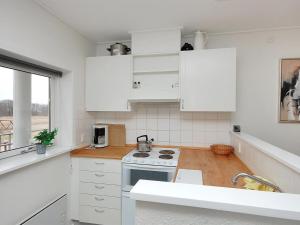 a kitchen with white cabinets and a stove top oven at Apartment Enni - 100m from the sea by Interhome in Hals