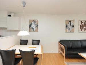 a dining room with a table and chairs and a couch at Apartment Enni - 100m from the sea by Interhome in Hals