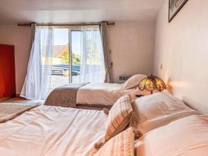 two beds in a room with a window at Holiday Home La houle by Interhome in Cancale