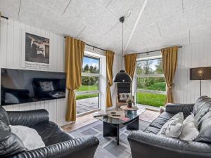 a living room with two leather couches and a table at Holiday Home Veijo - 400m to the fjord by Interhome in Spottrup