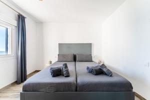 a bedroom with a large bed with two pillows at Newly Renovated 2 Bedroom Beachfront House in Sitio de Calahonda