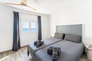 a bedroom with a large bed with towels on it at Newly Renovated 2 Bedroom Beachfront House in Sitio de Calahonda