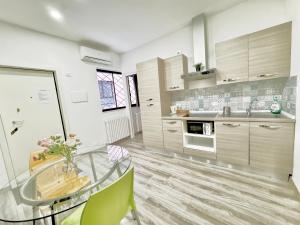 a kitchen with a glass table and green chairs at Indipendent Mini Apartment Pescara Centro in Pescara