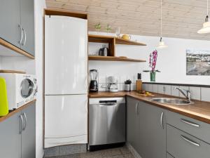 a kitchen with a white refrigerator and a sink at Holiday Home Thrugels - 600m from the sea by Interhome in Hadsund