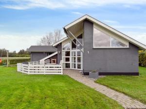 a gray house with a white fence at Holiday Home Thrugels - 600m from the sea by Interhome in Hadsund