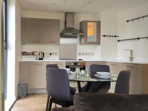 a kitchen with a table and chairs in it at Cozy Broad Street Apartment Central and Comfortable in Birmingham