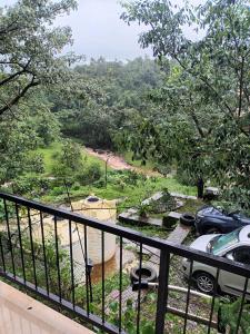 una vista desde el balcón de una casa en Girijalsrushti Mountain Stream View Villa, en Kolvan