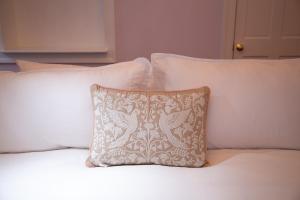 a white pillow sitting on top of a bed with pillows at Bosch House Rosé - Lila Suite in Savannah