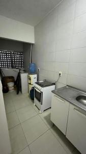 a small kitchen with a stove and a sink at Apartment Poncho Verde - Primavera do Leste, Mato Grosso in Primavera do Leste