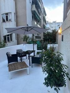 a patio with an umbrella and a table and chairs at JOHNMAR apartment in Athens