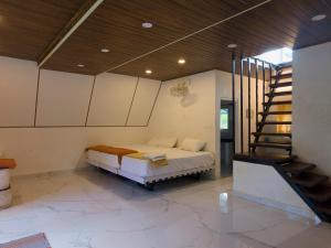 a bedroom with a bed and a staircase in a house at Pine Trees Gold in Vagamon +22 photos