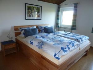 a bedroom with a bed with a blue and white comforter at Ferienwohnung Dachs in Zachenberg