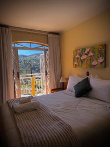 a bedroom with a large bed with a large window at Pousada Doce Vida in Campos do Jordão +48 photos