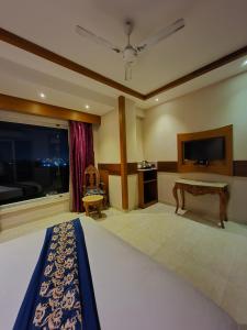 una camera da letto con un letto, una scrivania e una finestra di HOTEL KAVERI , a boutique hotel a Zirakpur