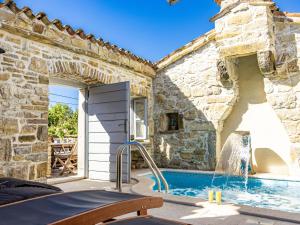een zwembad in een stenen huis met een fontein bij Holiday Home Franz by Interhome in Potpićan +25 foto's
