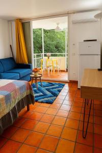 a living room with a blue couch and a table at Studio SUCRIER TARTANE in La Trinité