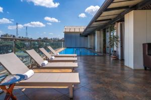 a row of lounge chairs on a balcony with a pool at Swiss Lenana Mount Hotel in Nairobi