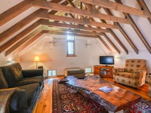 a living room with a couch and a table at Holiday Home The Granary by Interhome in Invermoriston