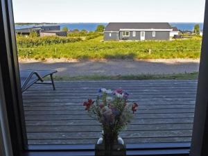 a vase of flowers sitting on a table with a window at Holiday Home Hildegunda - 600m from the sea by Interhome in Sjølund