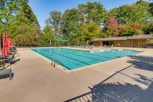 a large swimming pool with chairs and umbrellas at Festive Lakefront Escape Blue Ridge Holiday Home in Brevard