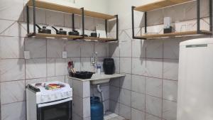 a small kitchen with a white stove top oven at 02 - Sinta-se em casa in Paragominas
