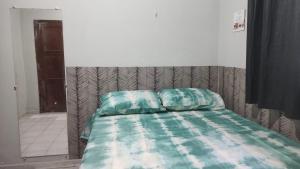 ein Schlafzimmer mit einem Bett mit einer grünen Bettdecke in der Unterkunft Sinta-se em casa in Paragominas + 6 Fotos