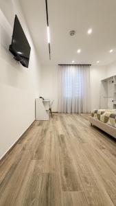 Una habitación blanca con una cama y un televisor en la pared. en Street316, en Cinisi