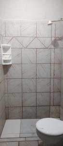 ein Badezimmer mit Toilette und gefliester Wand in der Unterkunft Sinta-se em casa in Paragominas