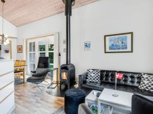 een woonkamer met een bank en een houtkachel bij Holiday Home Angantir - 4-8km from the sea by Interhome in Byrum