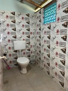 La salle de bains est pourvue de toilettes et d'une fenêtre. dans l'établissement Sukhi Beach Cottage, à Gokarna