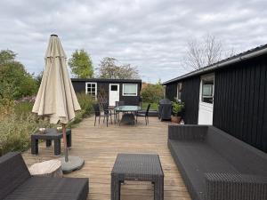 a patio with an umbrella and a table and chairs at Holiday Home Gun - 300m to the fjord by Interhome in Glostrup