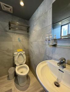 a bathroom with a toilet and a sink at 逢甲Cartoon in Hsia-shih-pi