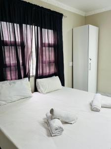 a bedroom with two towels on a bed with a window at Sunset in Durban