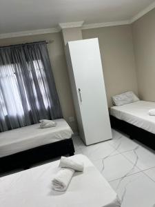 a room with two beds and a cabinet in it at Sunset in Durban