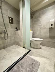 a bathroom with a toilet and a glass shower stall at 逢甲Cartoon in Hsia-shih-pi