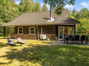 a house with chairs and a table in the yard at Holiday Home Hristijan - 4-8km from the sea by Interhome in Læsø