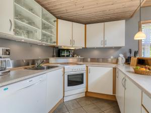 a kitchen with white cabinets and a sink at Holiday Home Hristijan - 4-8km from the sea by Interhome in Læsø