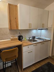 a kitchen with white cabinets and a sink at Apartment Maja - Strict center of Zagreb in Zagreb