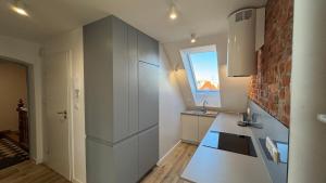 a kitchen with white cabinets and a window at OPOLSKA WENECJA-apartament typu STUDIO z tarasem in Opole