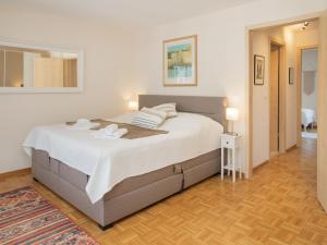 a bedroom with a large bed with white sheets at Apartment Residenz Marina-63 by Interhome in Bouveret