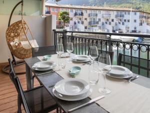 a table with plates and wine glasses on a balcony at Apartment Residenz Marina-63 by Interhome in Bouveret