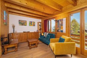 - un salon avec des chaises jaunes et un canapé bleu dans l'établissement Chalet Mouettes, à Riddes