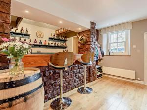 a bar with a brick wall and two stools at 3 Bed in Haile 90050 in Hale
