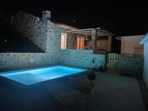 a swimming pool in a stone building at night at Casas da Lameirancha in Mação