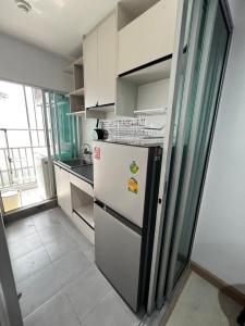 une cuisine avec un réfrigérateur blanc et une fenêtre dans l'établissement คอนโดเดอะคิทท์พลัส 113, à Ban Khlong Samrong