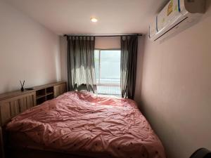 une petite chambre avec un lit et une fenêtre dans l'établissement คอนโดเดอะคิทท์พลัส 113, à Ban Khlong Samrong