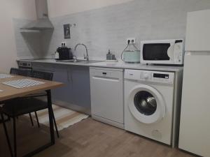 a kitchen with a washing machine and a microwave at Casas da Lameirancha in Mação +5 photos