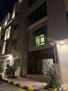 ein Gebäude in der Nacht mit Blumen davor in der Unterkunft 402 Elegant Studio with Self Check-in Al-Salmaniyah Neighborhood in Riad