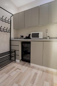 eine Küche mit weißen Schränken und einer Mikrowelle in der Unterkunft 402 Elegant Studio with Self Check-in Al-Salmaniyah Neighborhood in Riad + 8 Fotos