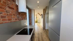 a kitchen with white counters and a brick wall at OPOLSKA WENECJA-apartament typu STUDIO z tarasem in Opole
